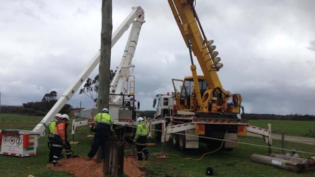 Western Power crews repairing fallen power poles.