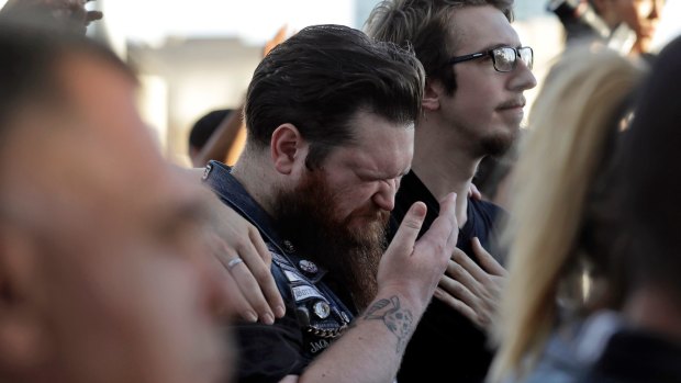 Sean Bolger is comforted by a friend during a vigil for the people killed in Las Vegas.