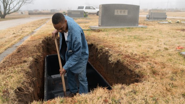 A worker digs a grave for Harper Lee in Monroeville, Alabama.