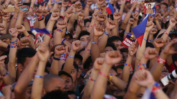 Supporters of Mr Duterte raise their clenched fists during his final campaign rally in Manila.