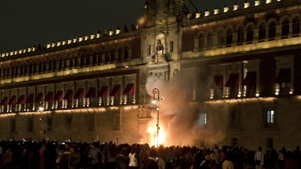 Hotheaded: Demonstrators set fire the door of the main entrance of the National Palace.