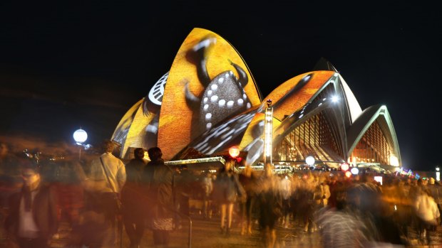 Coloured lights flood Circular Quay and the Opera House during Vivid.