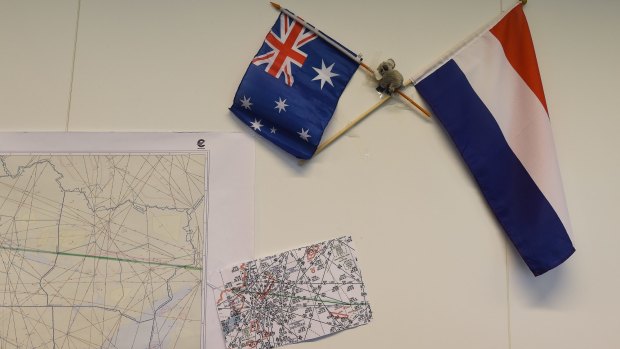 Australian and Dutch flags on the wall next to maps indicating the flight path of MH17 in the National Police of the Netherlands criminal investigation building in Driebergen.
