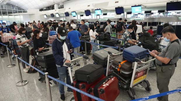 People queue up to check in at Hong Kong International Airport.