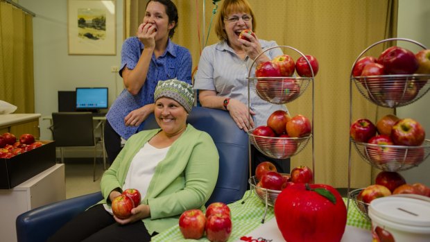 The Oncology unit at National Capital Hospital are ready to 'take the bite out' of their red apples to support Red Apple Day. Behind from left, Nurse Unit Manager for Oncology Kate Stafford, and Nurse Cathie Trotter. Front, National Capital Hospital patient Melissa Veal.