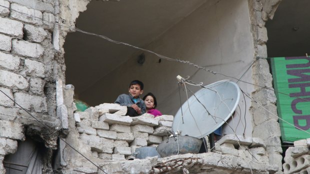 Children peer out from their destroyed home in Aleppo, Syria's largest city.