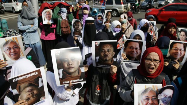 Muslim women hold posters of Wirathu, the leader of Myanmar's nationalist Buddhist monks, Myanmar's State Counsellor Aung San Suu Kyi, President Htin Kyaw, and Chief Senior Military General Min Aung Hlaing.