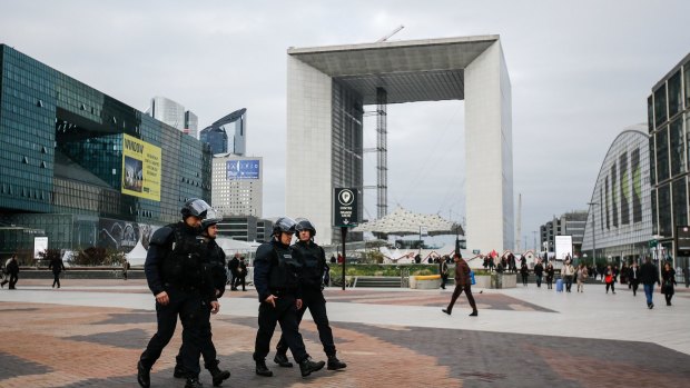 Armed police officers walk through La Defense, Paris, on the Monday after the Paris attacks.