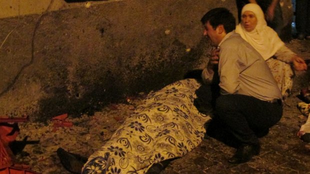 A man cries over a covered body after the Gaziantep blast.