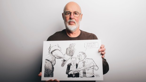 Former cartoonist for The Canberra Times, Geoff Pryor, with one of the cartoons now stored at the National Library of Australia, where he has just finished cataloging the work.