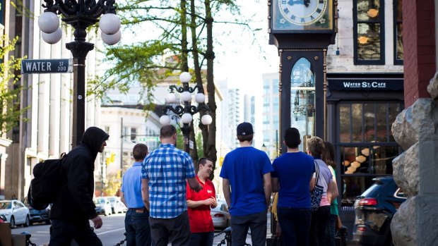 A guide for Vancouver Foodie Tours shows guests the steam clock in Gastown. 