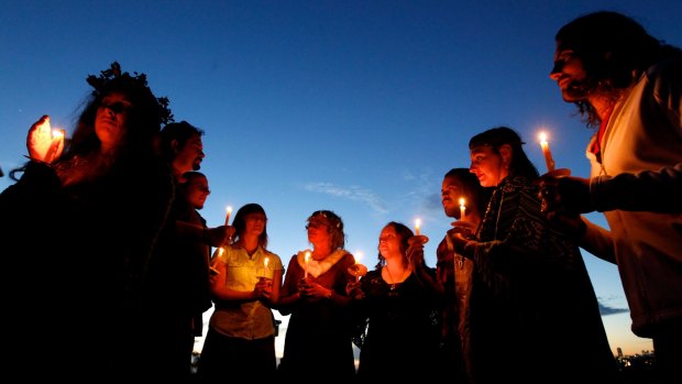 Pagans with lit candles gather at Observatory Hill to wait for Winter Solstice in June 2014.