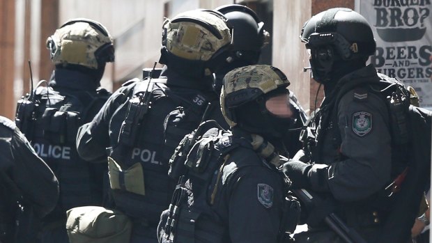 Police gather on the corner of Elizabeth Street and Martin Place, down from the Lindt cafe. 