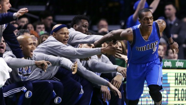 Welcome aboard: Dallas Mavericks guard Rajon Rondo is congratulated by his new teammates after the ex-Celtic hit a 3-pointer in front of the bench during the first quarter in Boston.