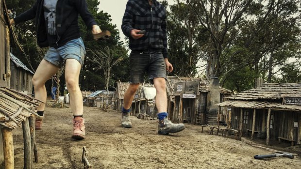 Land of the giants: crew members stomp through a miniature village.