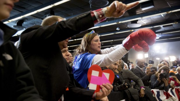 A member of the audience wears boxing gloves as she cheers before Democratic presidential candidate Hillary Clinton arrives to speak at her caucus night rally at Drake University in Des Moines, Iowa.