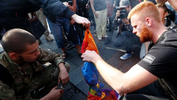 Ukrainian ultra nationalist activists burn a rainbow flag as they protest against the annual Gay Pride parade.