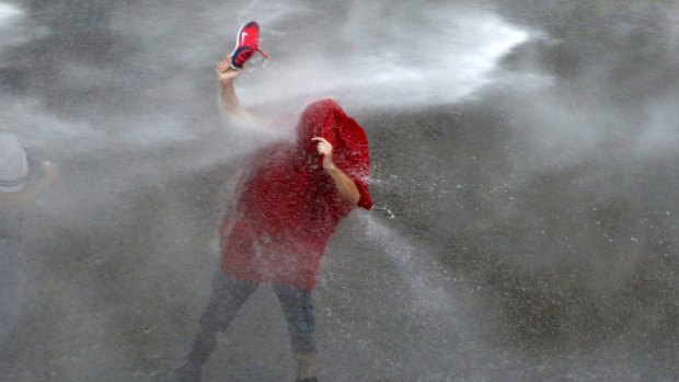 A Lebanese protester is sprayed with water near the government palace in Beirut.