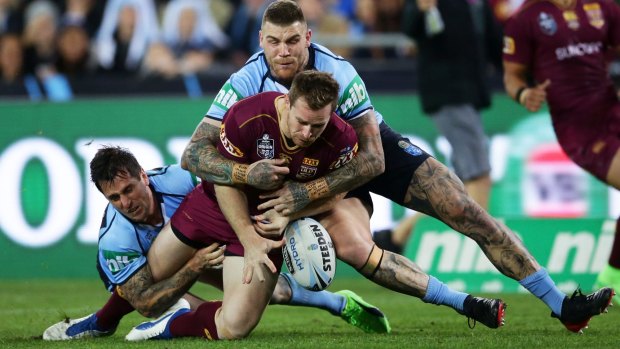 Solid defence: Michael Morgan of the Maroons drops the ball in a tackle by Mitchell Pearce and Josh Dugan.