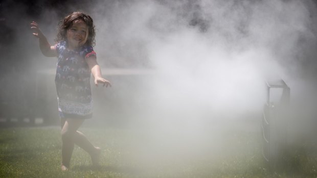 Three-year-old Eloise cools off under a sprinkler at the National Gallery of Victoria on Thursday.