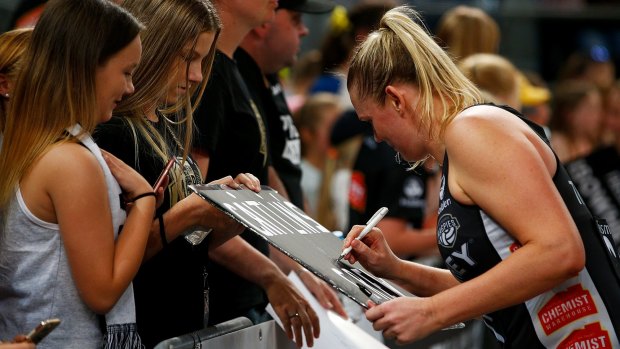 Magpie Caitlin Thwaites signs autographs after the win.
