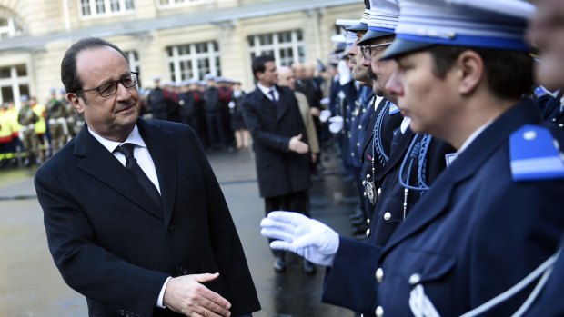 French President Francois Hollande shakes hands to police officers at the Paris' police headquarters, one year after the attack targeting the French satirical newspaper Charlie Hebdo that left 12 dead.