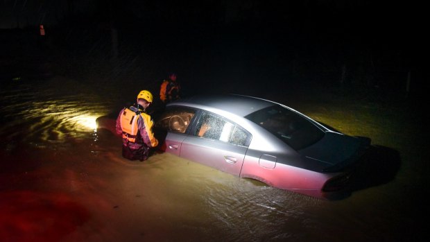 Rescue staff investigate an empty flooded car in Puerto Rico.