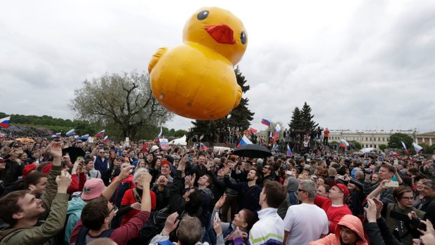 People play with a yellow duck toy, which symbolises Prime Minister Dmitry Medvedev's luxury house for raising ducks, during an anti-corruption rally in St Petersburg, Russia.