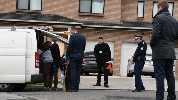 Detectives search a white work van outside the 24-year-old's house on Thursday morning. 