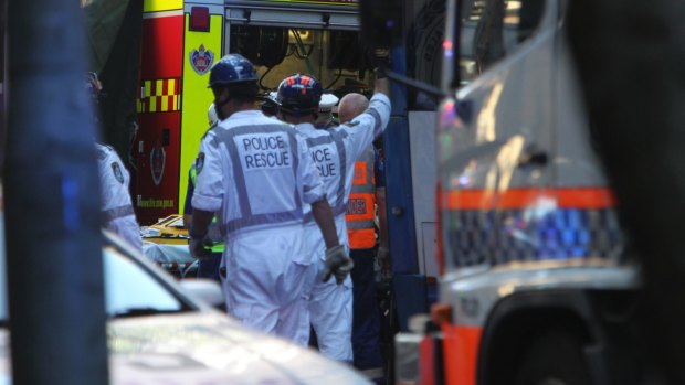 Emergency services work to free Christine Mulholland, who died after being hit by a bus on Clarence Street.