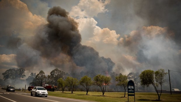 Black smoke and flames are visible from the road in Neath.