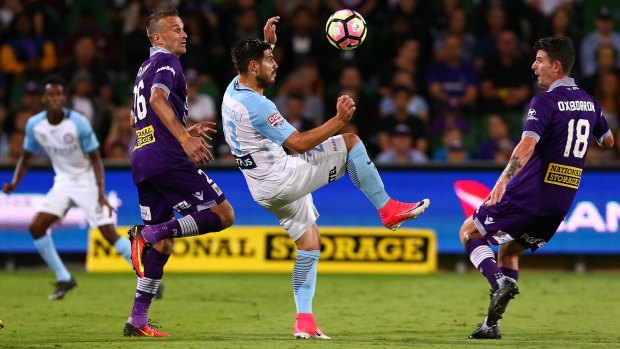 Melbourne's City Bruno Fornaroli controls the ball against Perth's Lucian Goian and Mitchell Oxborrow.