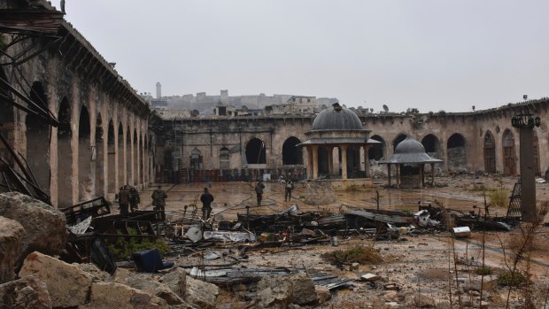 Syrian troops and pro-government gunmen inspect the destroyed Grand Umayyad mosque in the old city of Aleppo on Tuesday.