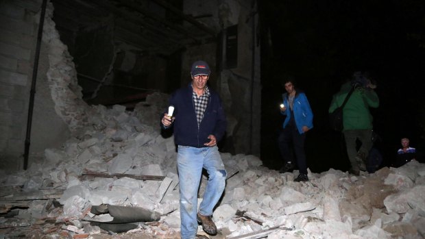 Residents walk past rubble in the village of Visso following the latest quake. 