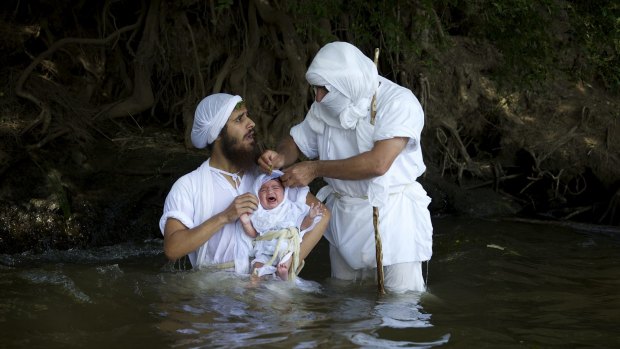 Members of the Mandaean community perform a ceremony in the Nepean River, Sydney.