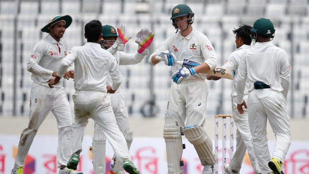 Bangladesh's Taijul Islam, second from right, celebrates with his teammates after the dismissal of Australia's Peter Handscomb, third from right, during the second day of the first Test in Dhaka.