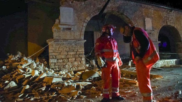 Rescuers stand by rubble in the village of Visso, central Italy, following several quakes on October 26.