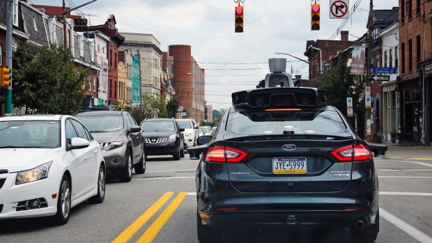 A self driving Uber car drives on Liberty Ave. through the Bloomfield neighborhood of Pittsburgh.