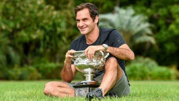 Winners are grinners: Roger Federer with his trophy on Monday. 