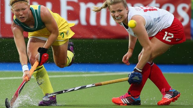 Tough conditions: water skids off the turf as Georgia Nanscawen of Australia hits a a shot away from Hollie Webb of England.