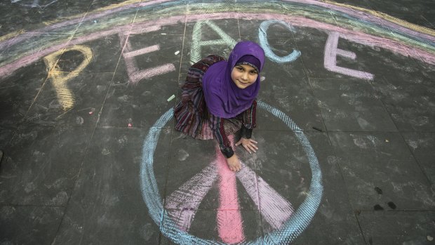 Seven-year-old Aaminah and her playmates drew messages of peace in chalk on the footpath outside ABC's Southbank offices.