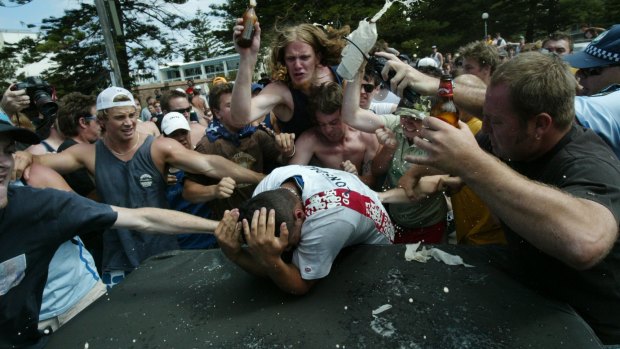 Geoffrey Atkinson, wearing a green shirt and camouflage cap, joins the mob of men attacking Safi Merhi during the Cronulla riots.