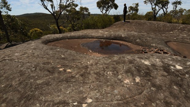 Whale and eel carvings can be seen in the foreground at Moon Rock.