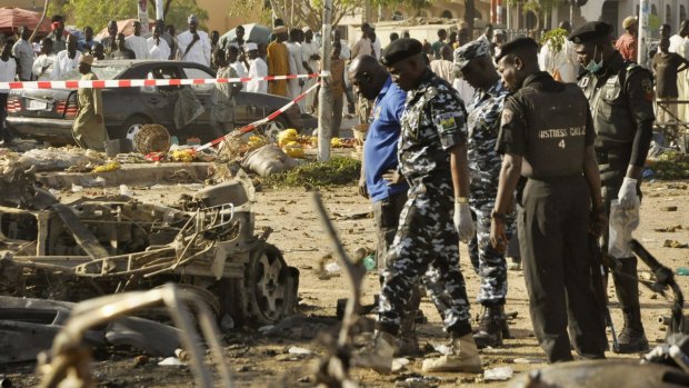 Bomb detection security personnel inspect the wreckage of a car believed to have been used in the bombing on Saturday.