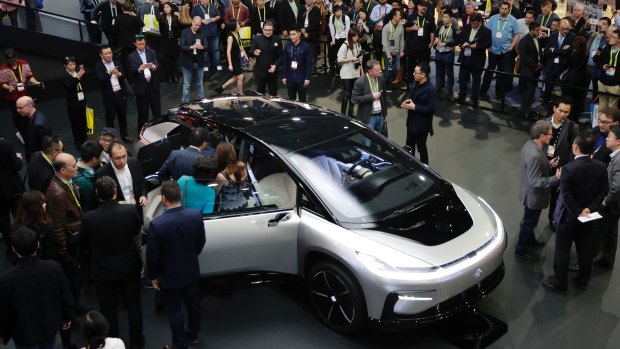 People gather around the Faraday Future's FF 91 electric car at CES 2017, in Las Vegas.