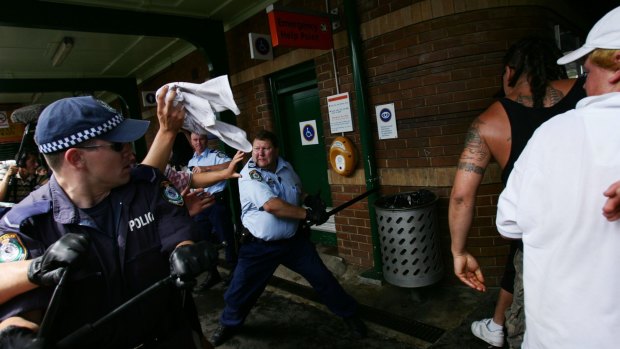 Craig Campbell, pictured with his baton, fends off violent youths during the Cronulla riots in 2005.