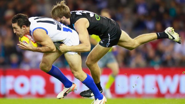 Michael Firrito of the Kangaroos is tackled by Justin Westhoff of the Power.