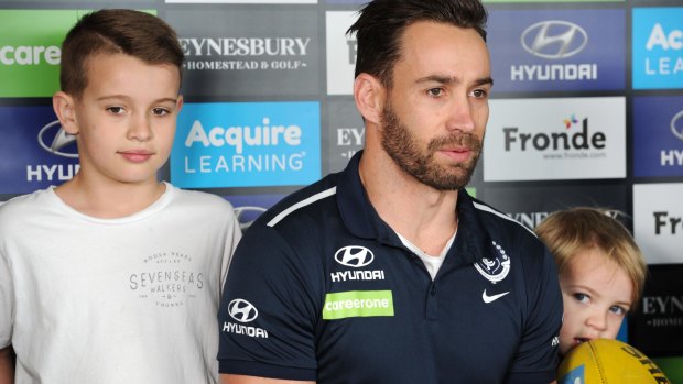 Carlton footballer Andrew Walker announcing his retirement with his children Cody (left) and Arli (right) at Ikon Park.