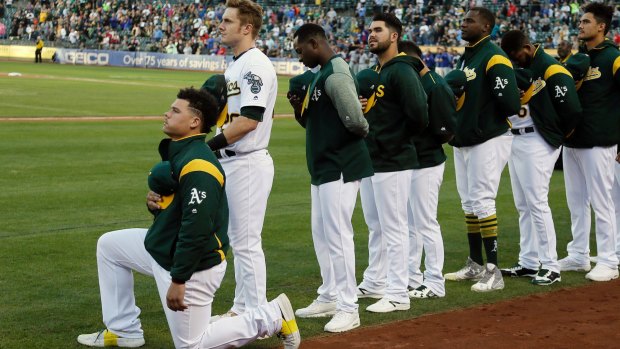 Oakland Athletics catcher Bruce Maxwell kneels during the national anthem.