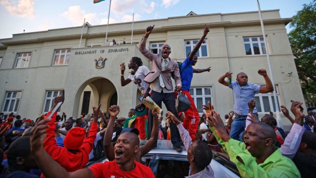 Zimbabweans celebrate outside Parliament on Tuesday after hearing that Robert Mugabe had resigned.